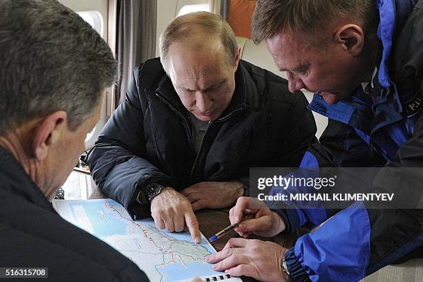 Russian President Vladimir Putin , accompanied with Deputy Prime Minister Dmitry Kozak and head of the Federal Road Agency Roman Starovoyt, points at...