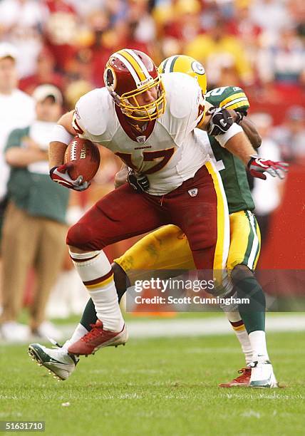 Chris Cooley of the Washington Redskins struggles to break a tackle against the Green Bay Packers at FedEx Field on October 31, 2004 in Landover,...