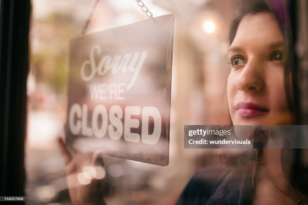 Business Woman Turning Closed Sign on Door of coffee Shop