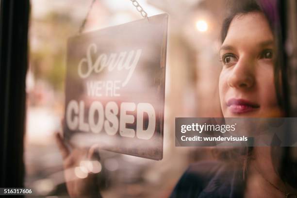 business woman turning closed sign on door of coffee shop - closing door stockfoto's en -beelden