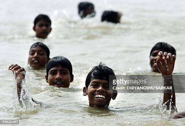 Young Indian slum dwellers enjoy a bath in a pool of rainwater in Madras 01 November 2004. The southern Indian state of Tamil Nadu, of which Madras...