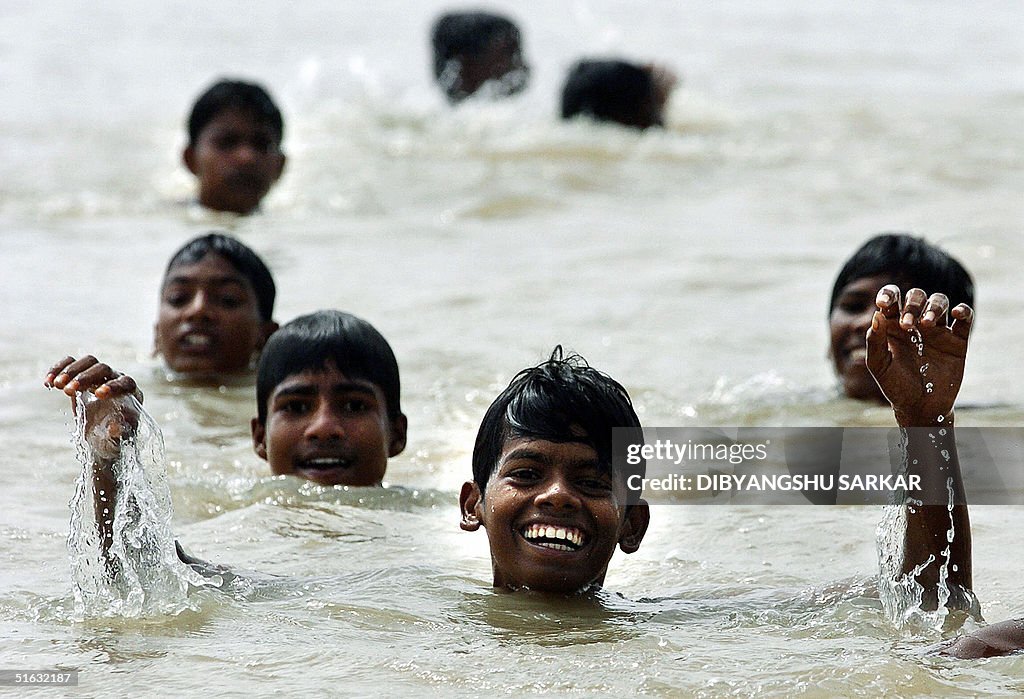 Young Indian slum dwellers enjoy a bath