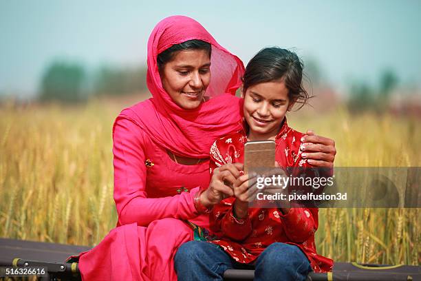 mutter und tochter mit smartphone - indian mother daughter stock-fotos und bilder