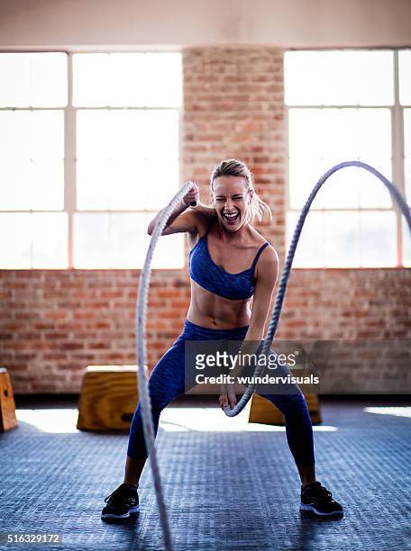 atlético chica efforting en crossfit entrenamiento en gimnasio con cuerdas - strength training fotografías e imágenes de stock