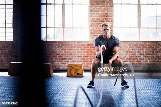 man doing battle ropes exercise during gym training at gym - crosstraining bildbanksfoton och bilder