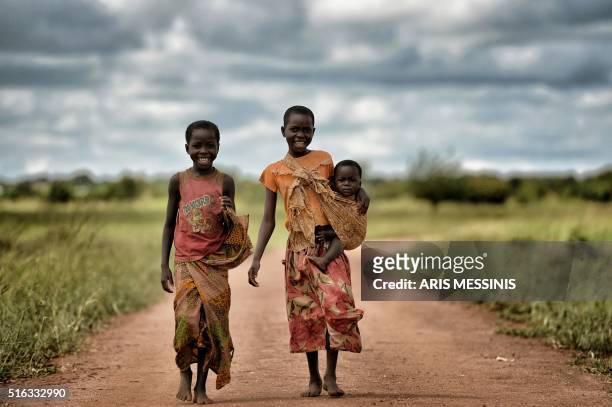 Children look on as they walk in the outskirts of Lilongwe on March 11, 2016. / RESTRICTED TO EDITORIAL USE