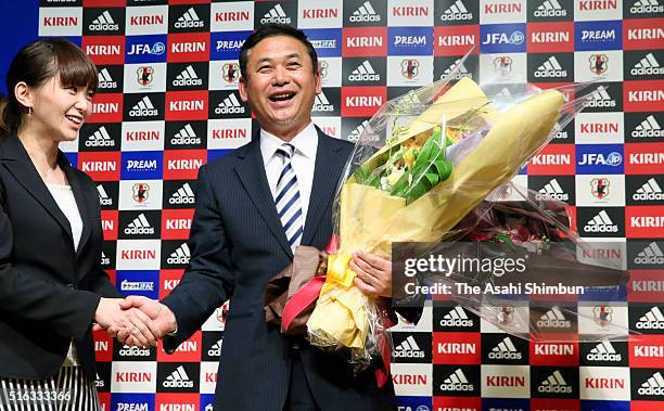 Outgoing Japan women's football national team head coach Norio Sasaki receives a flower bouquet during a press conference announcing to step down at...