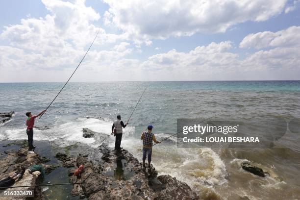 Syrian men fish in the coastal city of Latakia, the provincial capital of the heartland of the president's Alawite sect, on March 18, 2016.
