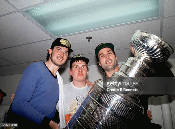 Mario Lemieux, Tom Barrasso and Paul Coffey of the Pittsburgh Penguins celebrate with the Stanley Cup after defeating the Minnesota North Stars in...