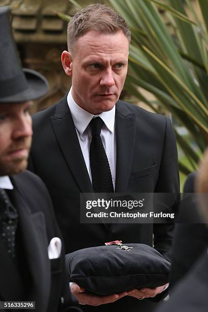 Actor Antony Cotton carries the MBE of Coronation Street scriptwriter Tony Warren at his funeral at Manchester Cathedral on March 18, 2016 in...