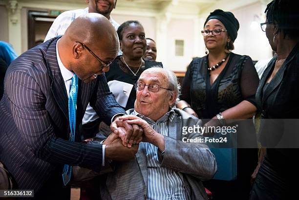 South Aricas minister of Arts and Culture, Nathi Mthethwa shakes hands with one of the defendants from the Rivonia Trial, Denis Goldberg during the...