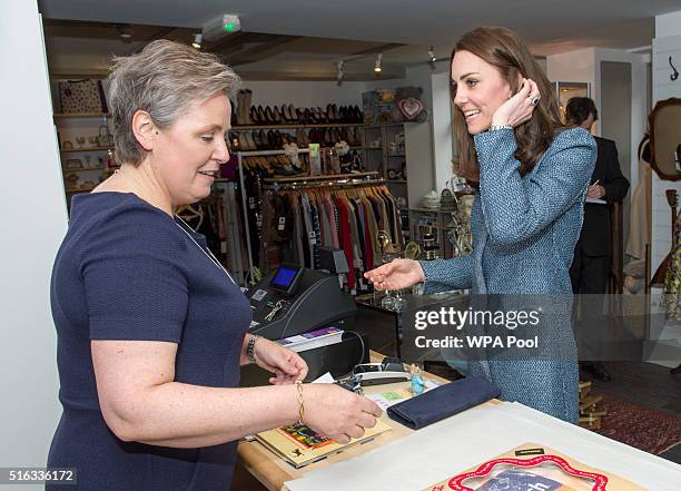 Catherine, Duchess of Cambridge buys some items, including a Fireman Sam book for Prince George, as she takes a tour of the new EACH charity shop...