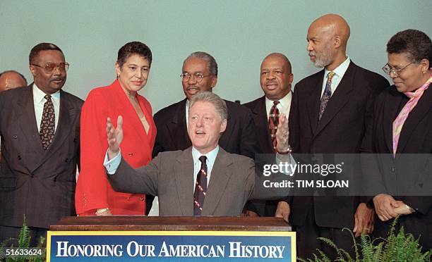 President Bill Clinton sits in front of members of the "Little Rock Nine" Jefferson Thomas, Carlotta Wall LaNier, Ernest Green, Rep. Elijah Cummings,...