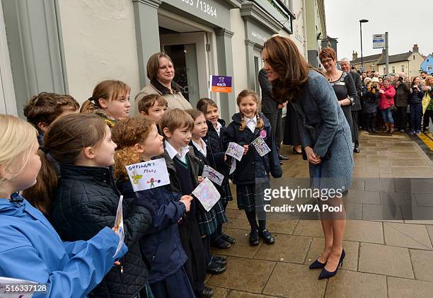 Catherine, Duchess of Cambridge meets children from a local school as she arrives to officially open the new EACH charity shop on March 18, 2016 in...