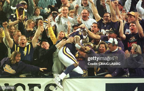 Minnesota Vikings' Randy Moss celebrates with the crowd after scoring a touchdown on a long pass from Randall Cunningham early in the fourth quarter...