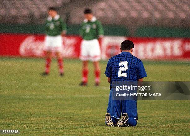 El Salvador National Team player William Osorio kneels during a minute of silence for the victims of Hurricane Mitch in Central America prior to a...