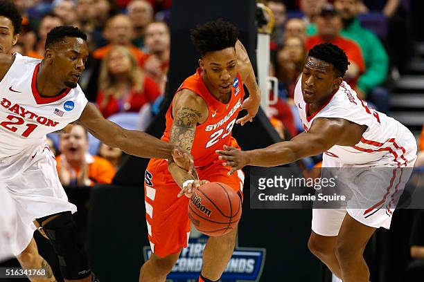 Malachi Richardson of the Syracuse Orange handles the ball in the first half against Dyshawn Pierre and Kendall Pollard of the Dayton Flyers during...