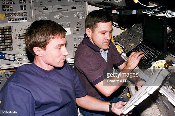 Space shuttle Endeavour crewmembers Russian Sergei Krikalev and US Commander Bob Cabana check readings 08 December from the US Unity connecting...