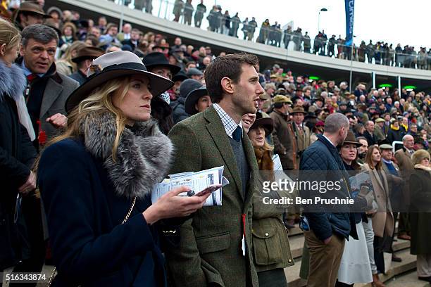 Racegoers watch a race in the parade ring during Gold Cup day at the Cheltenham Festival at Cheltenham Racecourse on March 18, 2016 in Cheltenham,...