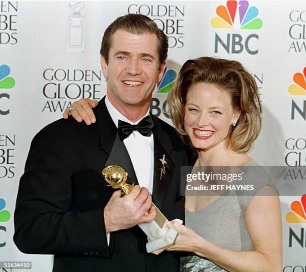 Director/actor Mel Gibson holds his Golden Globe Award 21 January with US actress Jodie Foster by his side as they pose together in Beverly Hills...