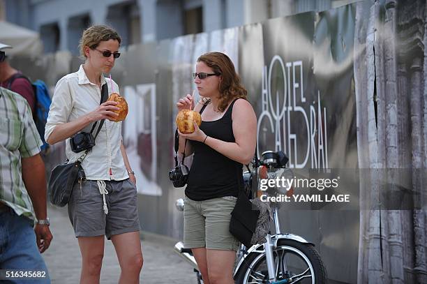 Tourists drink coconut water in Havana on March 18, 2016. US president Barack Obama touches down in Havana on Sunday to cap a long-unimaginable...