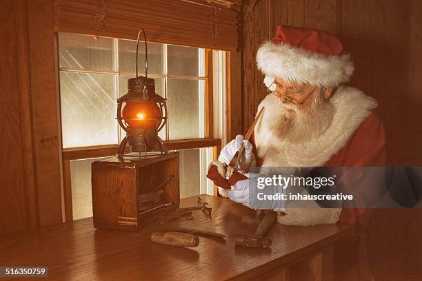 real santa claus working late night - santas workshop stock pictures, royalty-free photos & images