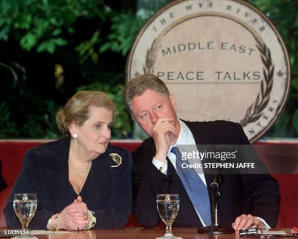 Secretary of State Madeleine Albright talks with US President Bill Clinton as he opens the Plenary Session of the Middle East Peace Talks at the Wye...