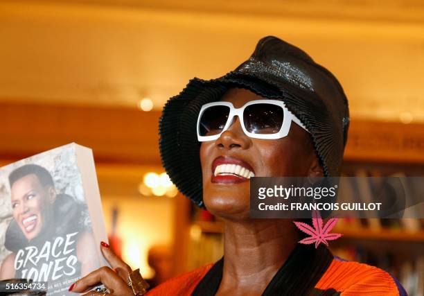 Performer Grace Jones poses with her book as she attends a book signing for her new autobiography "I'll Never Write My Memoirs," at the Bon Marche in...