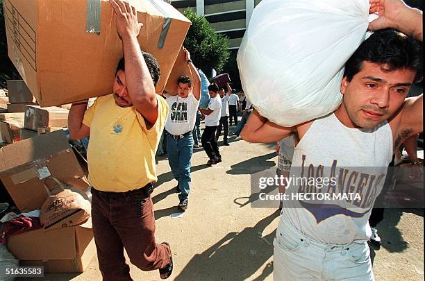 Group of volunteers carry boxes with food and medicines for the victims of Hurricane Mitch in Honduras 04 November. Local officials fear more than...