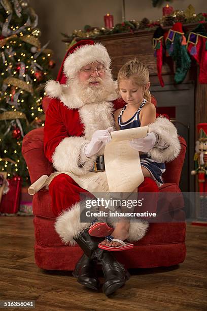 real santa claus reading naughty nice list - naughty santa stock pictures, royalty-free photos & images