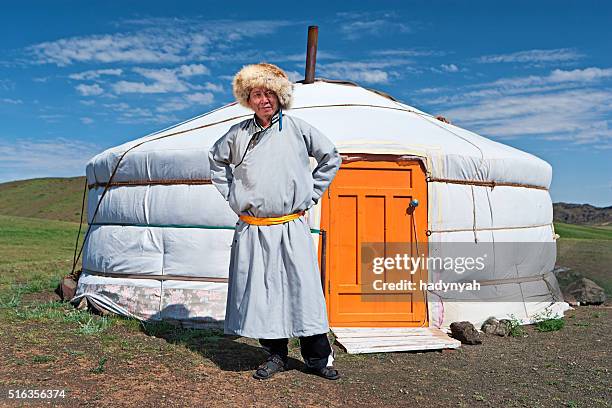 mongolian man in national clothing standing next to ger - mongolian culture stock pictures, royalty-free photos & images