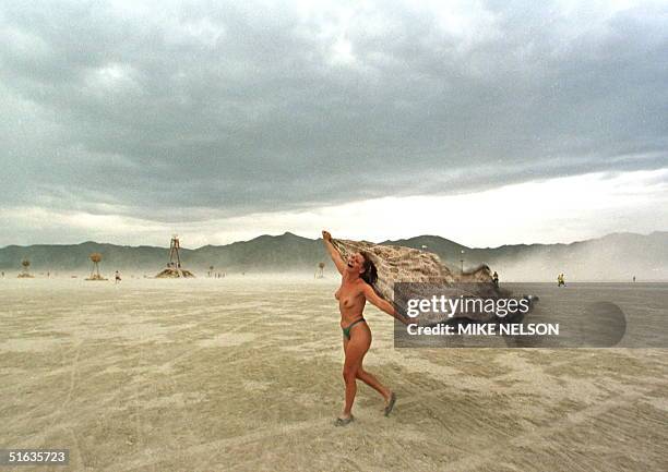 Audra dances on the windswept playa of the Black Rock Desert in northern Nevada during the Burning Man Festival 05 September. Over 10,000 people have...