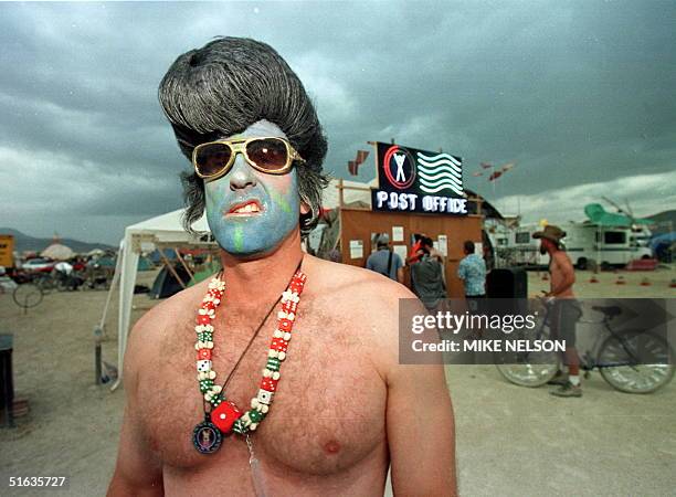 Mark, from Las Vegas, dressed as a blue faced Elvis Presley sneers near the Burning Man Post Office 05 September at the Burning Man Festival in the...