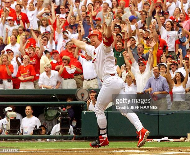 Mark McGwire of the St. Louis Cardinals celebrates after hitting his 61st homerun against Chicago Cub's Mike Morgan at Busch Stadium 07 September in...