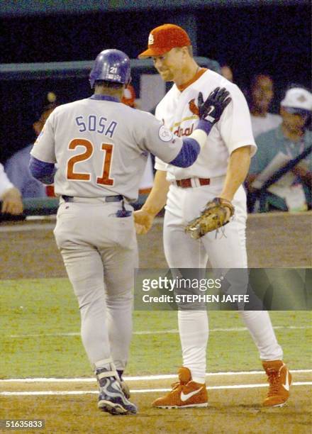 Sammy Sosa of the Chicago Cubs slaps Mark McGwire of the St. Louis Cardinal after hitting a single in the first inning of action against the Chicago...