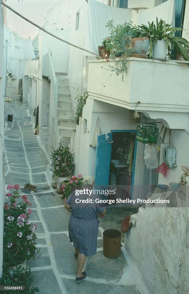 Paros Naousa street with lady walking to her house