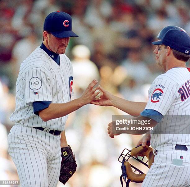 Chicago Cubs' relief pitcher Terry Adams hands the ball to manager Jim Riggleman after giving up three runs and allowing two consecutive Milwaukee...