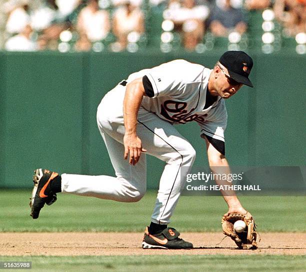 Baltimore Orioles third baseman, Cal Ripken, fields an infield grounder and throws to second base to force out Anaheim Angels runner, Norberto Martin...