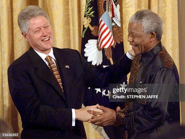 President Bill Clinton shakes hands with South African President Nelson Mandela at a reception for African American religious leaders, black college...