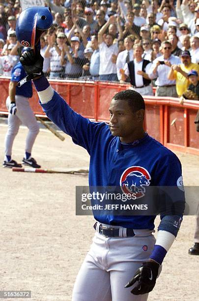 Sammy Sosa of the Chicago Cubs waves to the crowd after hitting his 65th home run against the Milwaukee Brewers 23 September at County Stadium in...