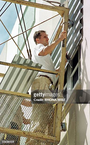 Worker from Art Construction locks down the windows of a hotel on Miami Beach, FL 24 September in preparation for the arrival of Hurricane Georges....