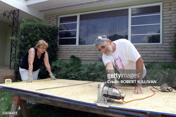 Besty and Jerry Stewartson cut plywood to board up their windows in preparation of Hurricane Georges 24 September in Miami Shores, FL. Georges is...