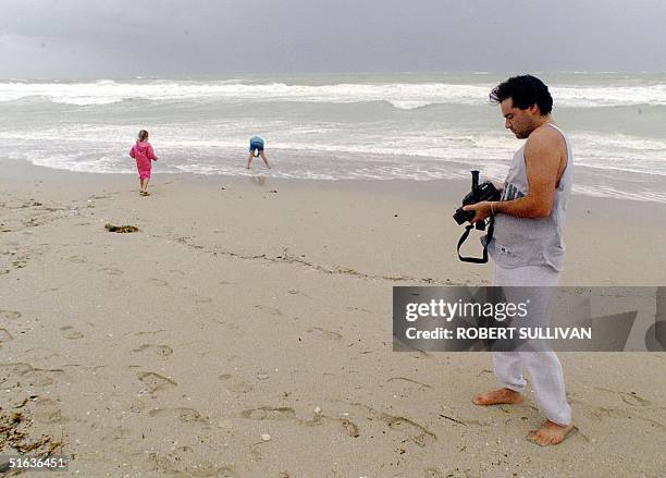 Len Bronsick of Miami films his daughters playing in the surf created by Hurricane Georges on Miami Beach 25 September. The eye of Georges is passing...