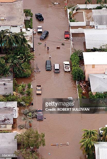 Residents make their way down a flooded street in Key West, FL 26 September in the aftermath of Hurricane Georges. The eye of Georges is passed over...