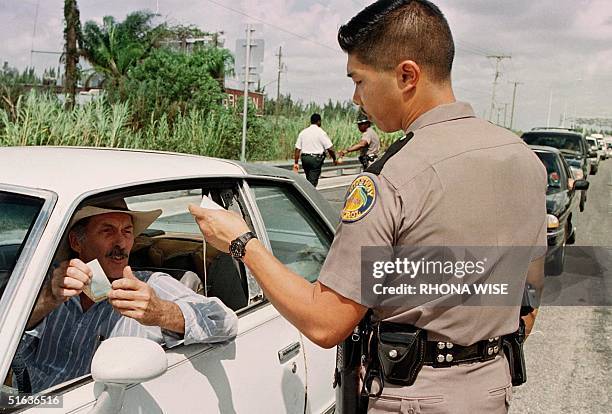 Florida State Trooper Peter Chord asks a Florida Keys resident for identification 26 September outside FLorida City, FL, as residents of the Florida...