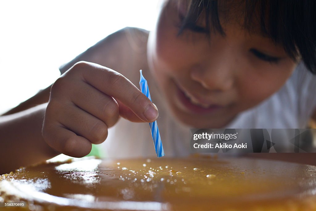 Girl holding candle on cake