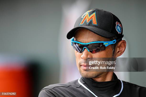 Ichiro Suzuki of the Miami Marlins looks on from the dugout before heading out to the field during the sixth inning of the spring training game...