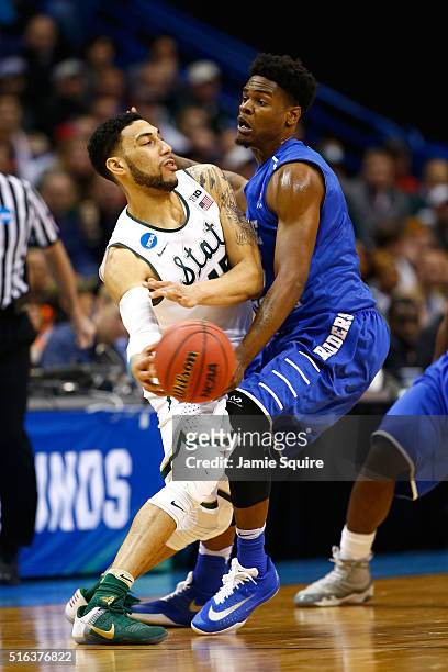 Denzel Valentine of the Michigan State Spartans looks to pass against Aldonis Foote of the Middle Tennessee Blue Raiders in the second half during...