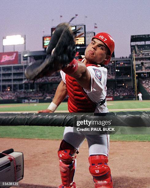 Ivan Rodriguez of the Texas Rangers reaches in to the photographer's well to catch a pop foul against the Los Angeles Dodgers 01 July at The Ballpark...