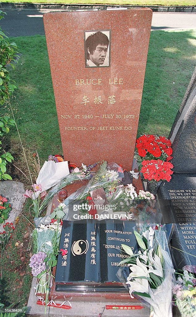 Flowers and incense decorate the headstone of Bruc